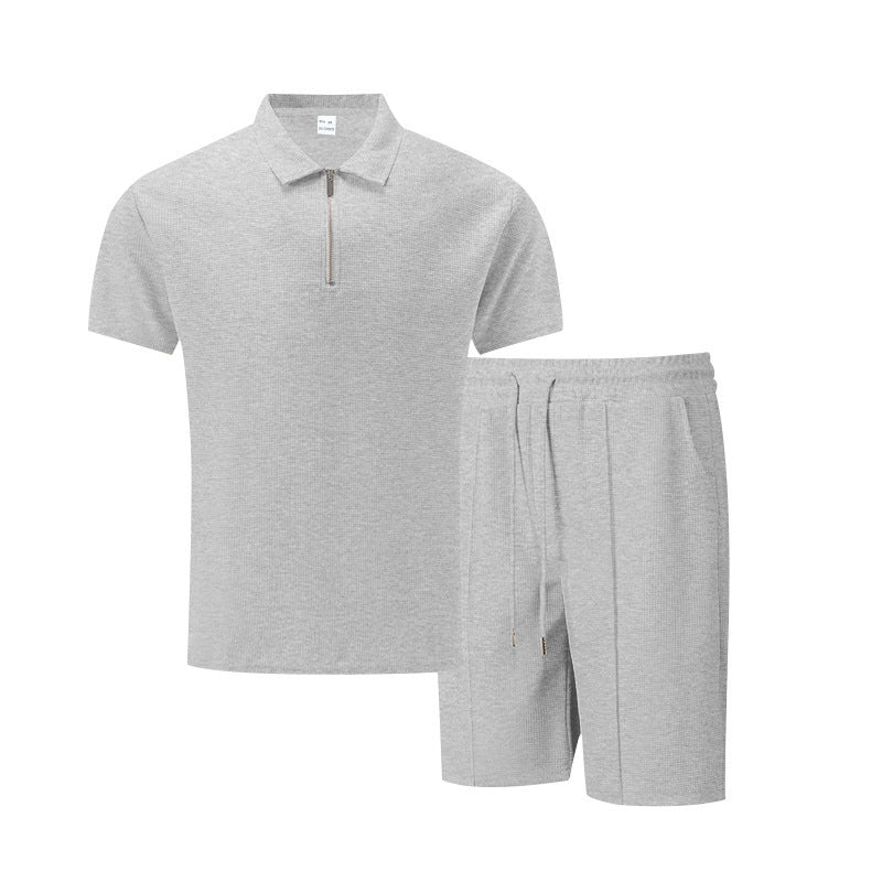 Gray polo shirt and shorts set on a white background