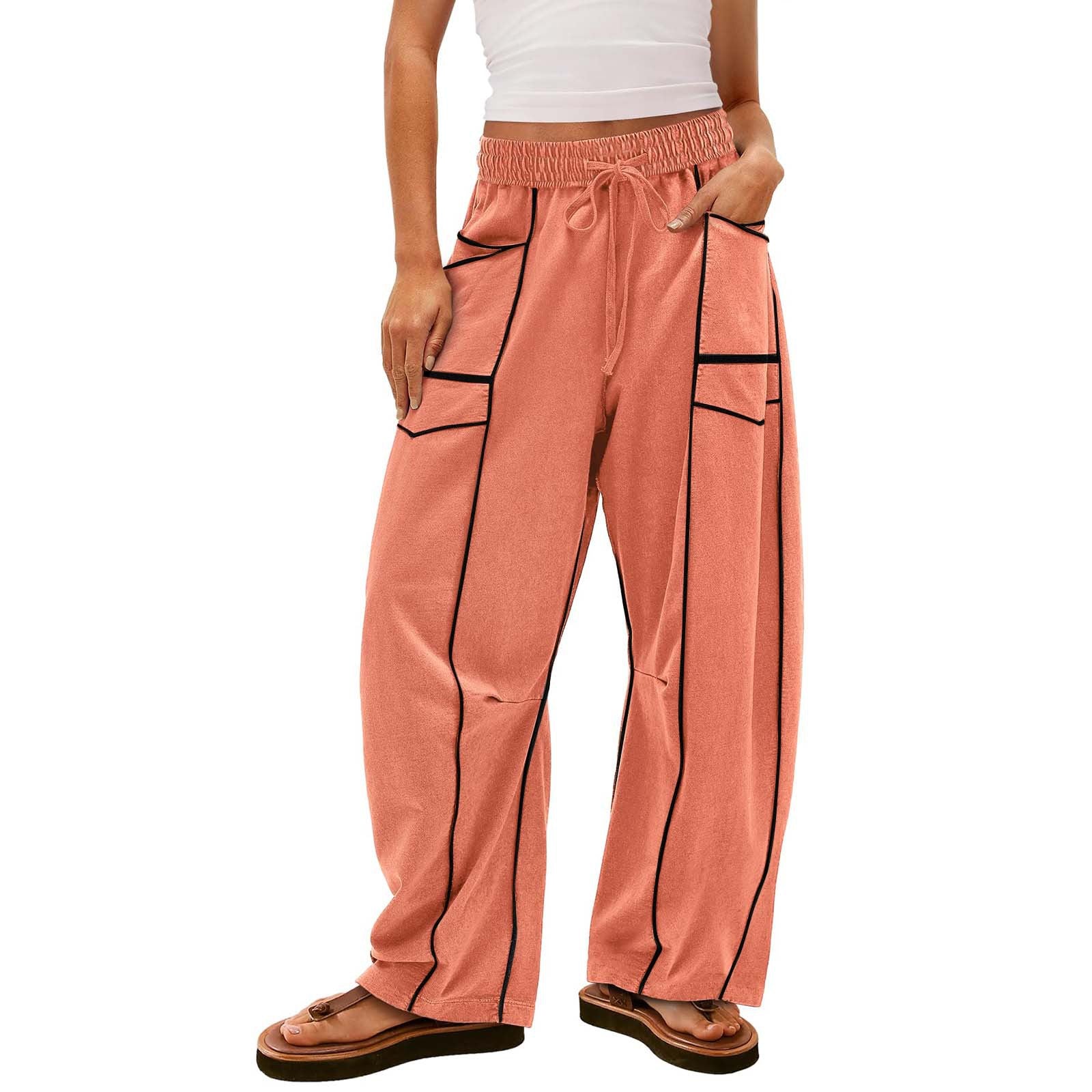 Person wearing peach-colored pants with black accents on a white background