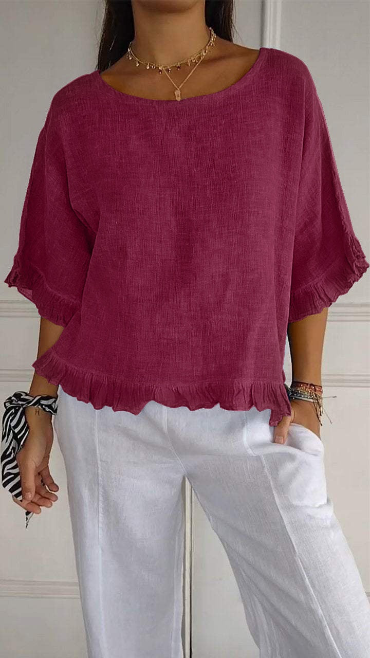 Person wearing a magenta top and white pants against a neutral background