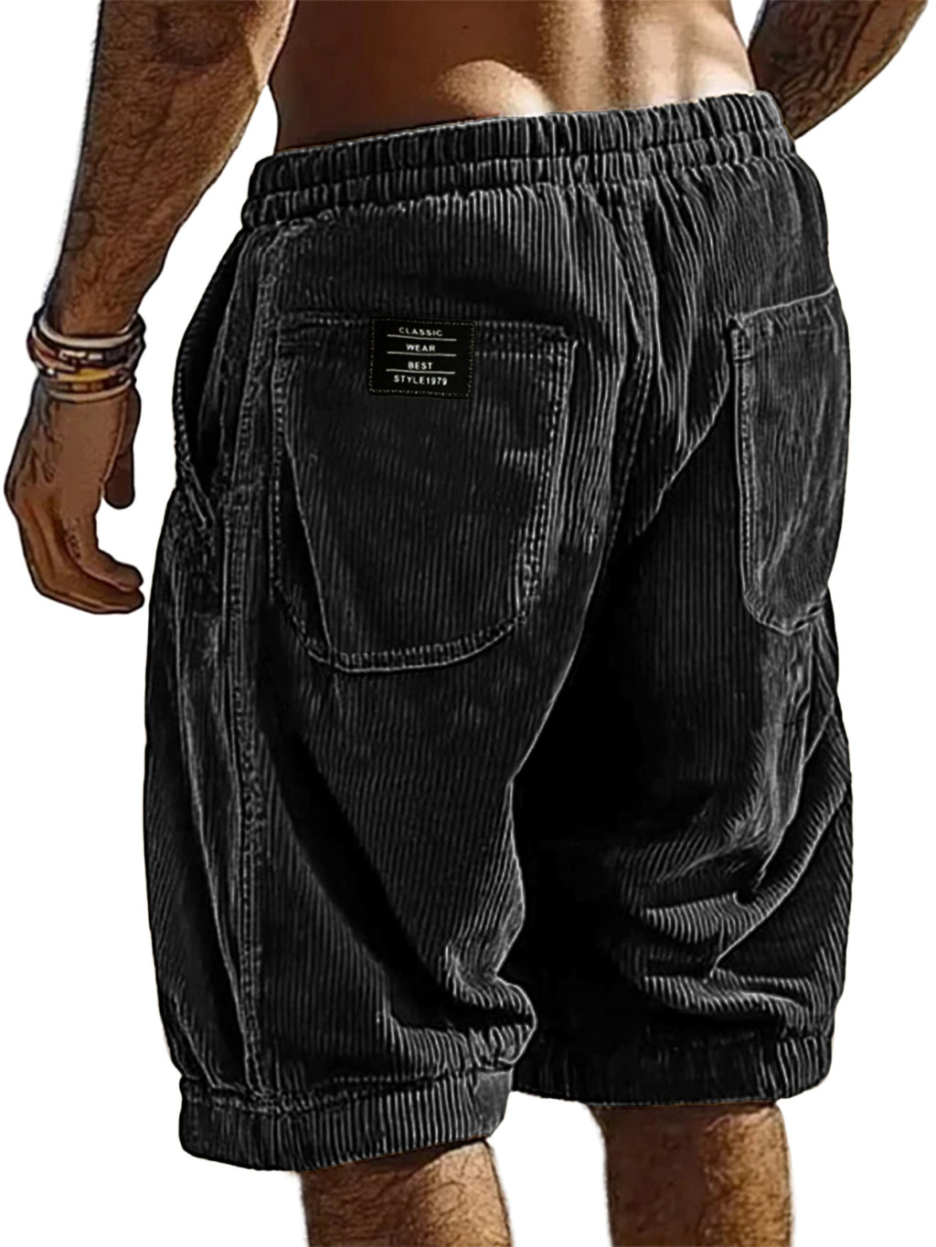 Black corduroy shorts worn by a person on a white background