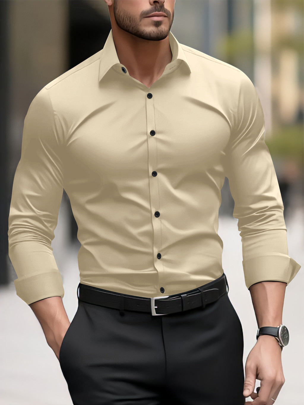 Man wearing a beige button-up shirt and black pants with a blurred background