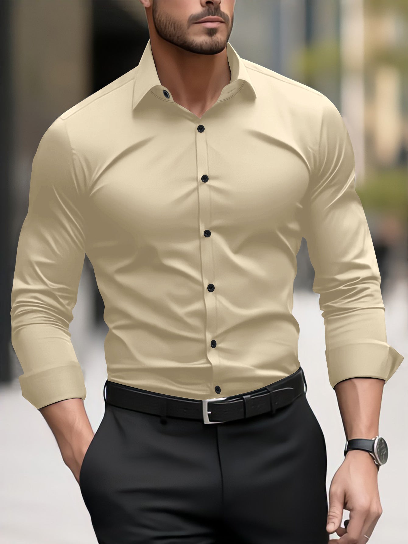 Man wearing a beige button-up shirt and black pants with a blurred background