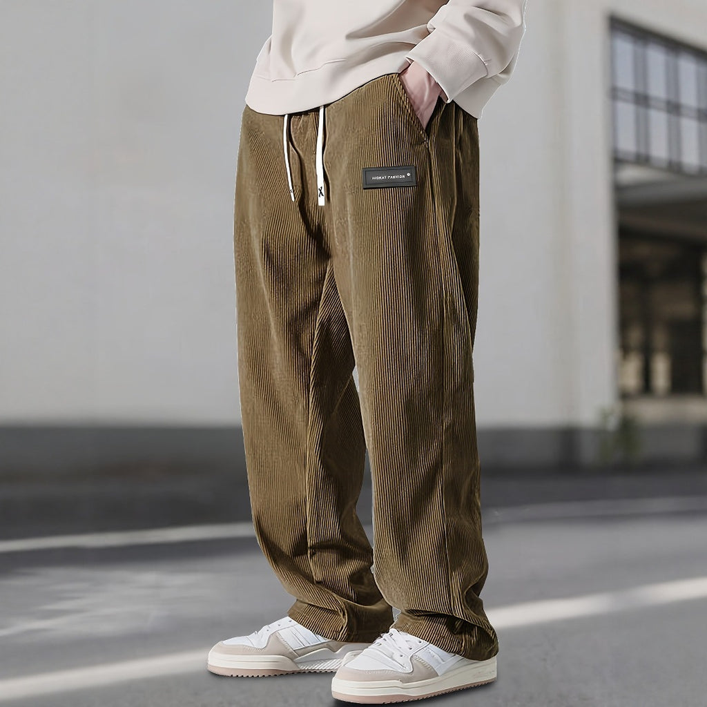 Person wearing brown corduroy pants with a blurred background