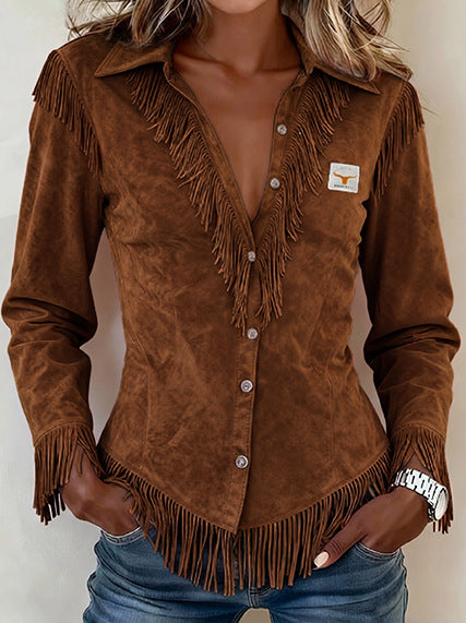A woman wearing a brown suede western-style fringed shirt jacket with a V-neck and button front, paired with blue jeans.