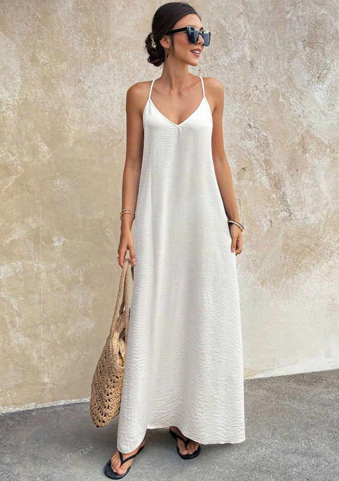 Woman wearing a white slip dress against a beige wall