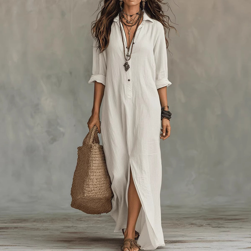 Woman wearing a long white dress holding a woven bag against a neutral background