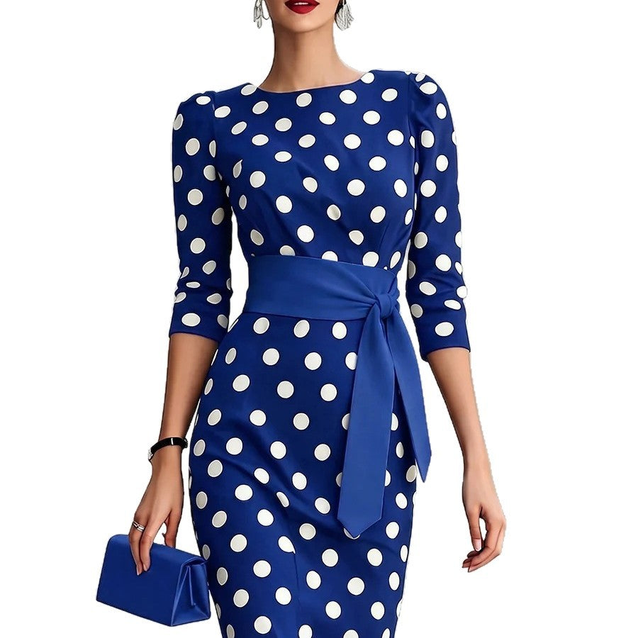 Woman wearing a blue dress with white polka dots on a white background