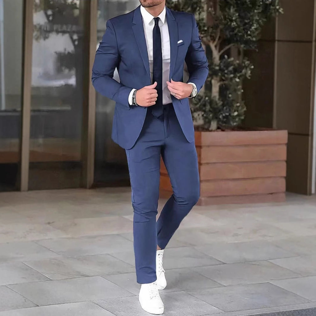 Man in a blue suit with white shoes standing outdoors.