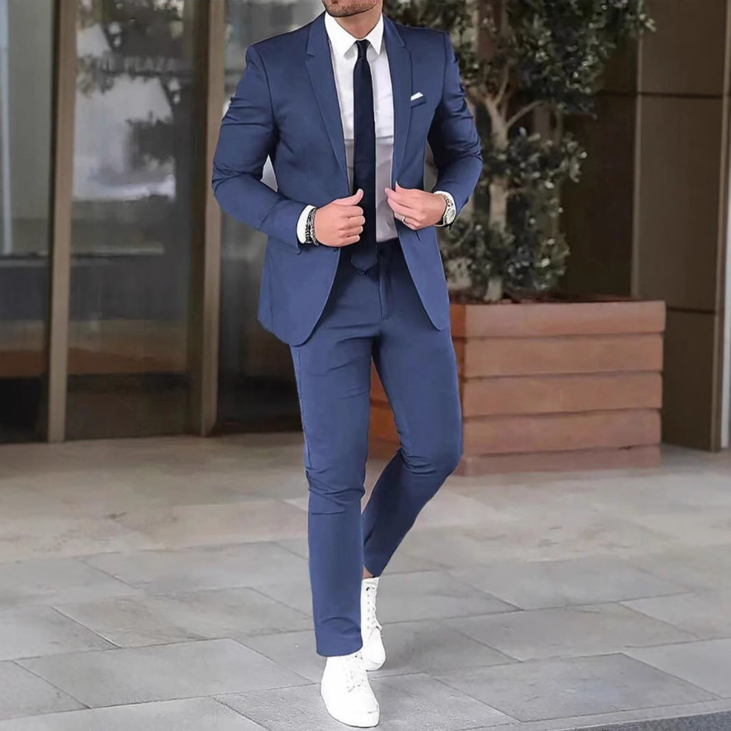 Man in a blue suit with white shoes standing outdoors.