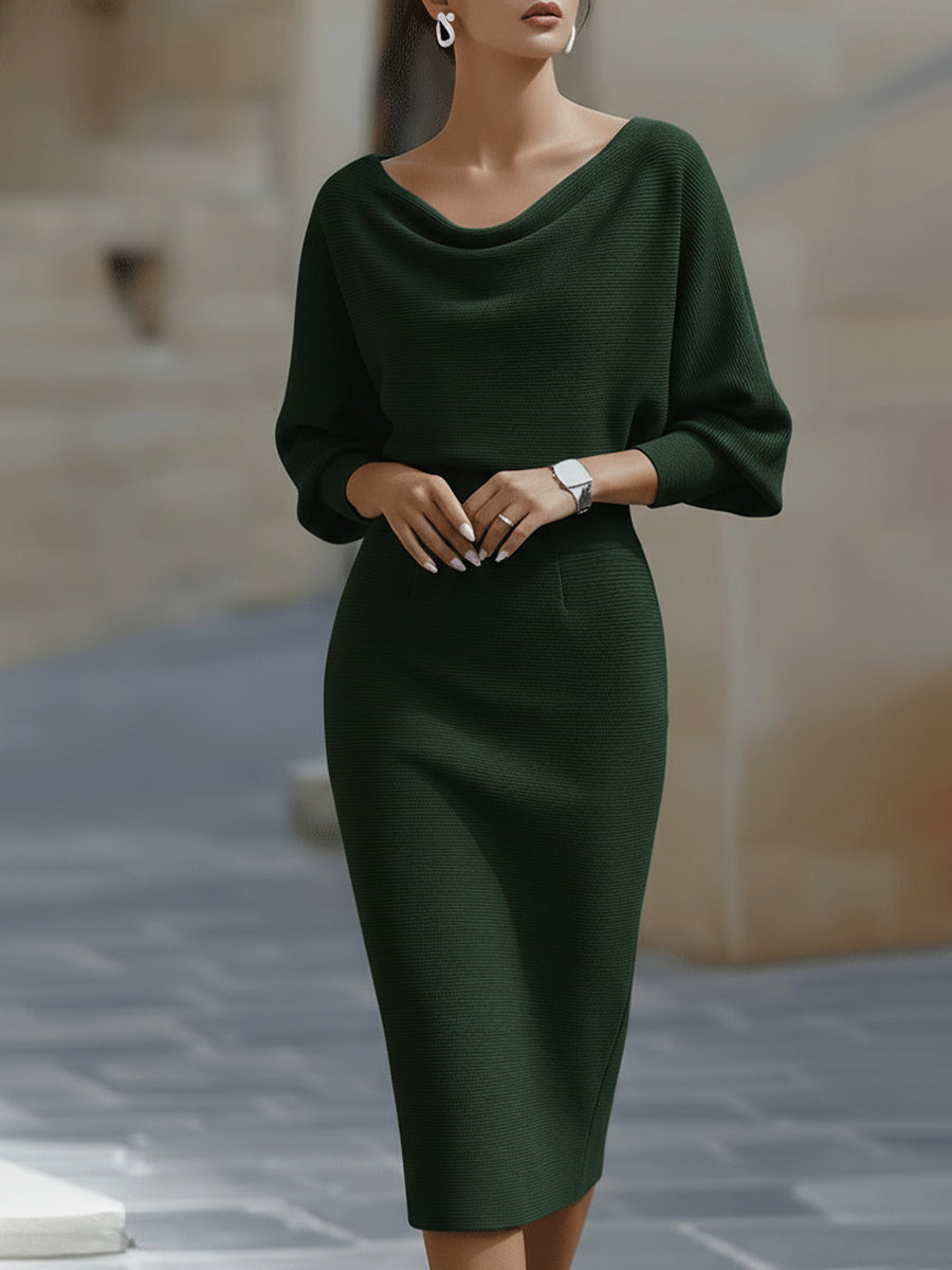 Woman wearing a green dress standing on a stone pavement.