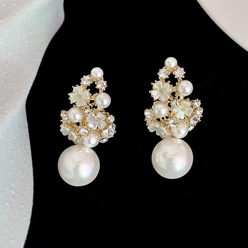 Pair of pearl and crystal earrings on a black background