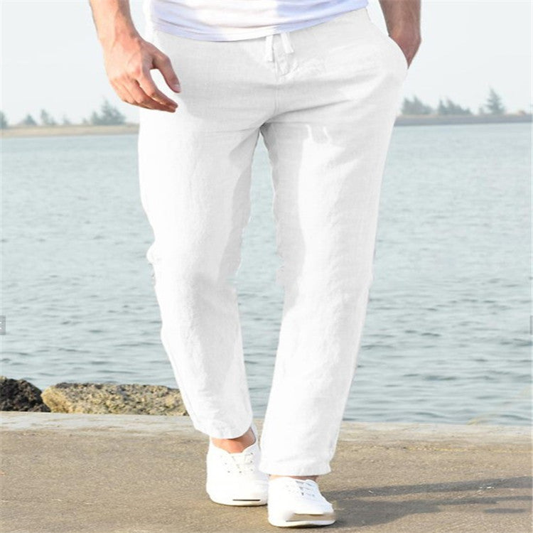 Person wearing white pants standing by a body of water