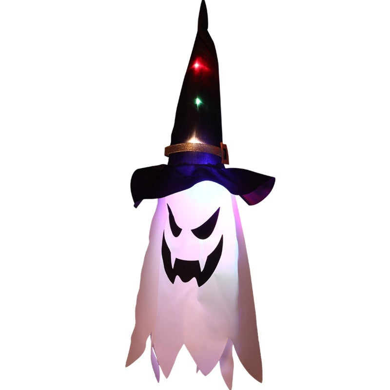 Halloween-themed decoration with ghost face and witch hat on a white background
