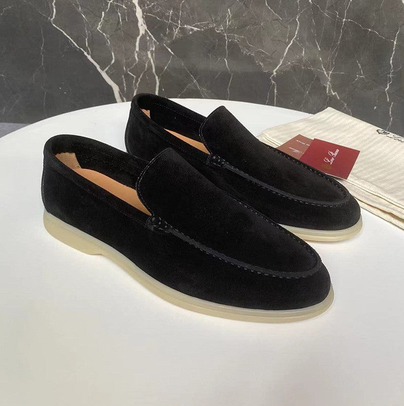 Black loafers on a white surface with a marble-patterned background