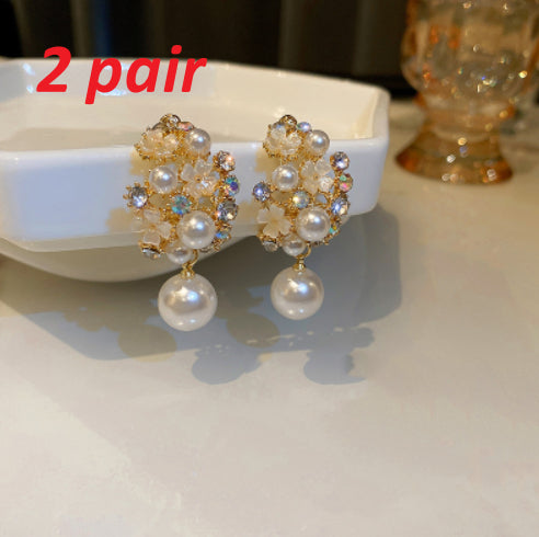 Pair of pearl earrings on a white dish with '2 pair' text.