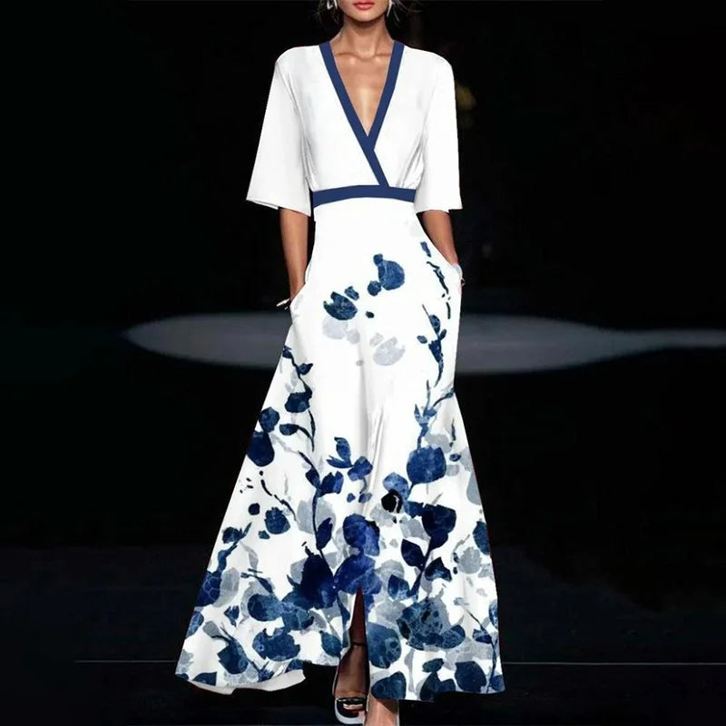Woman wearing a white dress with blue floral patterns on a dark background