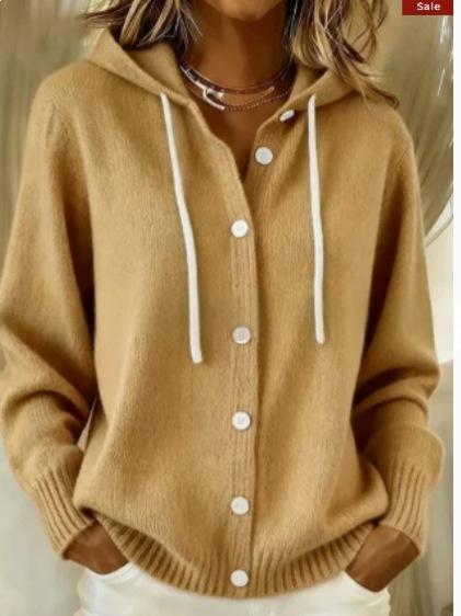 A woman wearing a camel-colored knit hooded cardigan sweater with white drawstrings and white buttons, paired with white pants. The image has a 'Sale' tag in the top right corner.
