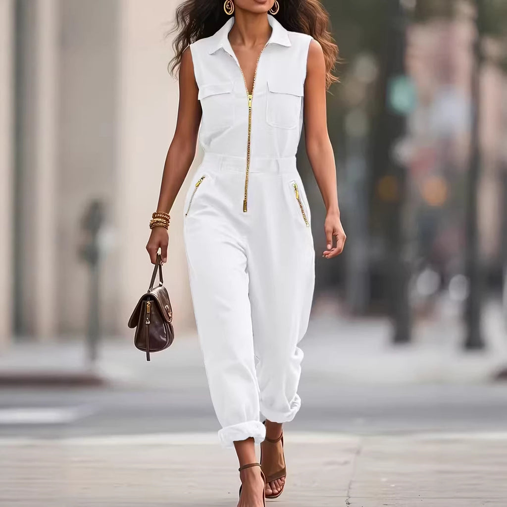 Woman in a white sleeveless jumpsuit walking on a city street.