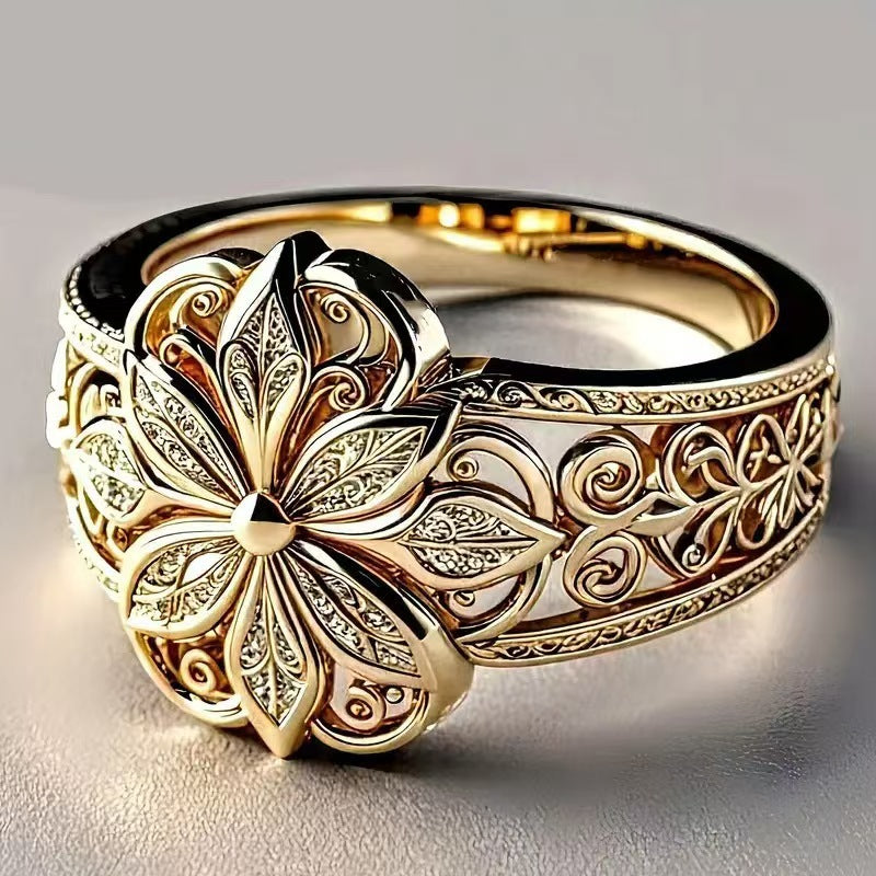 Gold ring with intricate floral design on a gray background