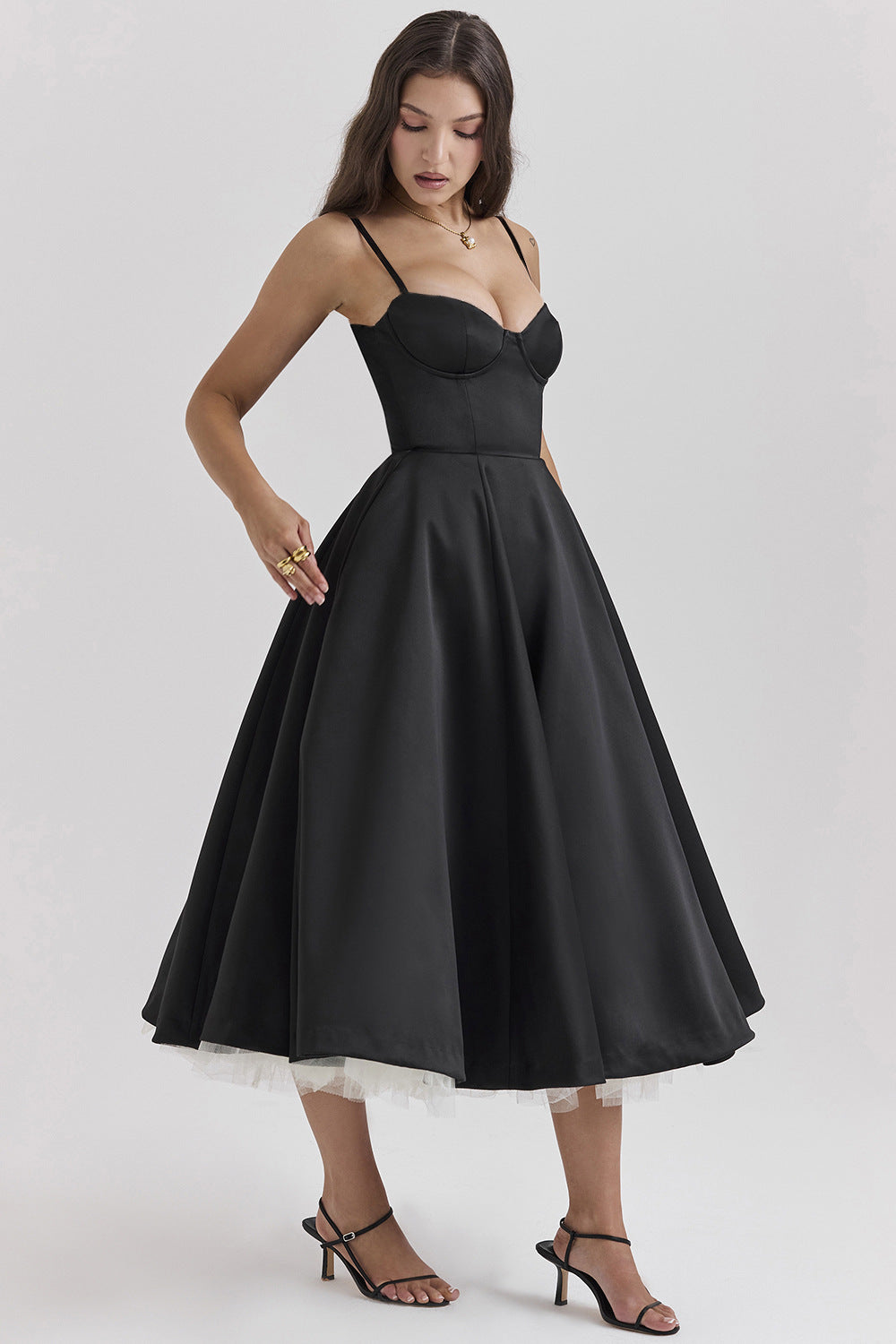 Woman wearing a black dress with a white lace hem on a light gray background