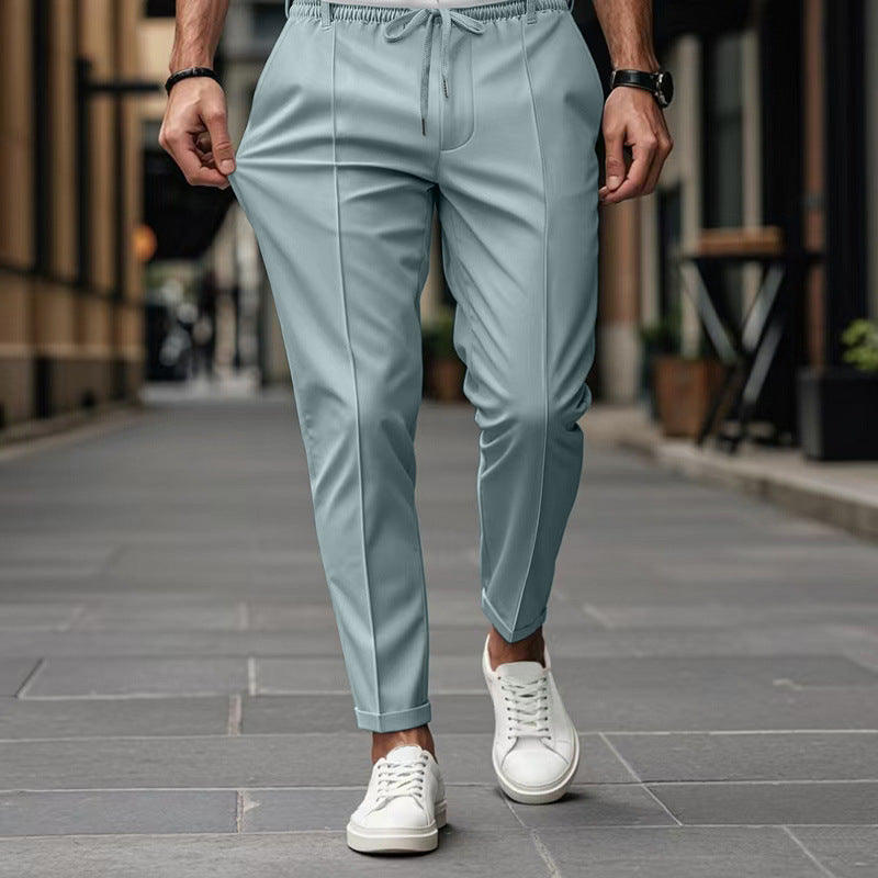 Person wearing light blue pants and white sneakers on a city street.