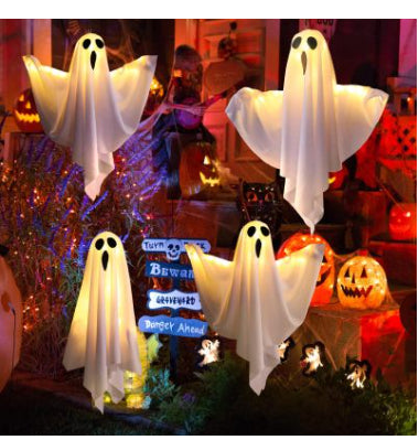 Halloween decorations including ghost figures and pumpkins in a festive setting.