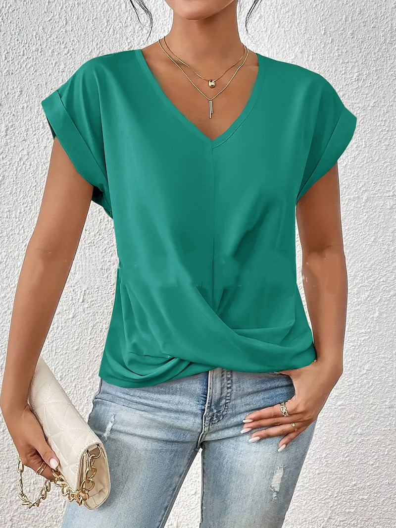 Woman wearing a green top and blue jeans against a white background