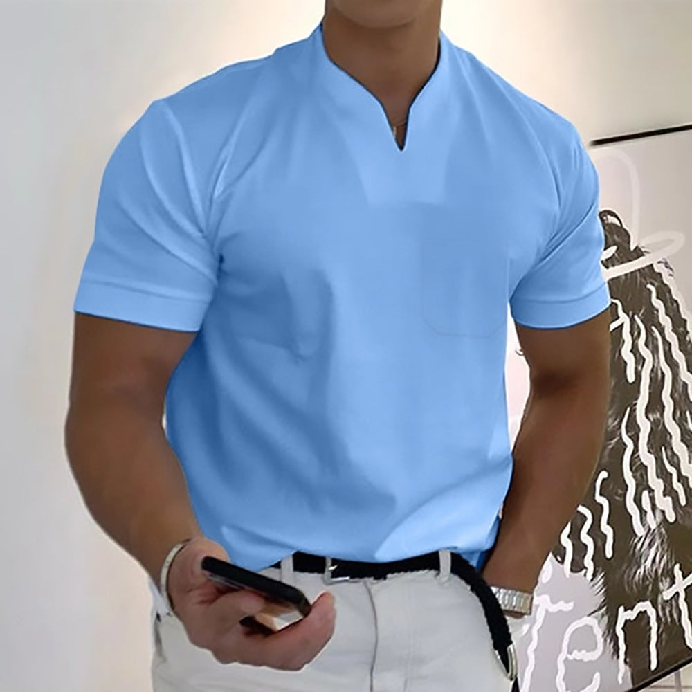 Person wearing a light blue polo shirt and white pants, holding a phone.