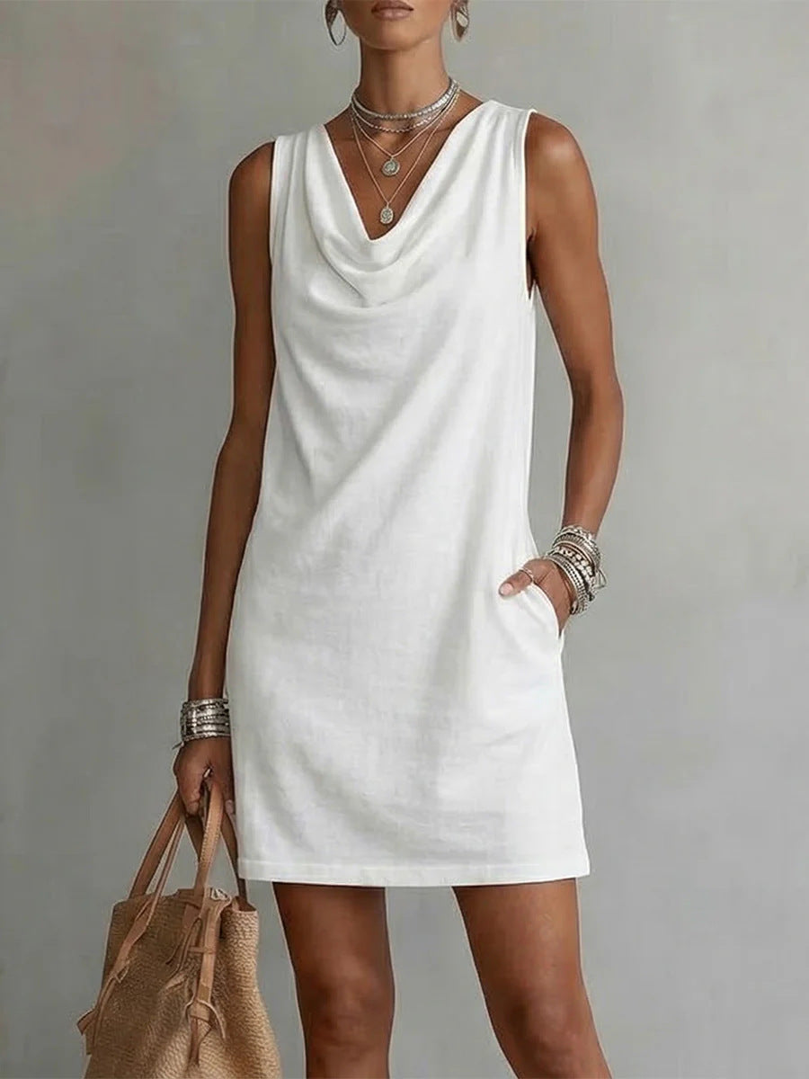 Woman wearing a white sleeveless dress against a plain background