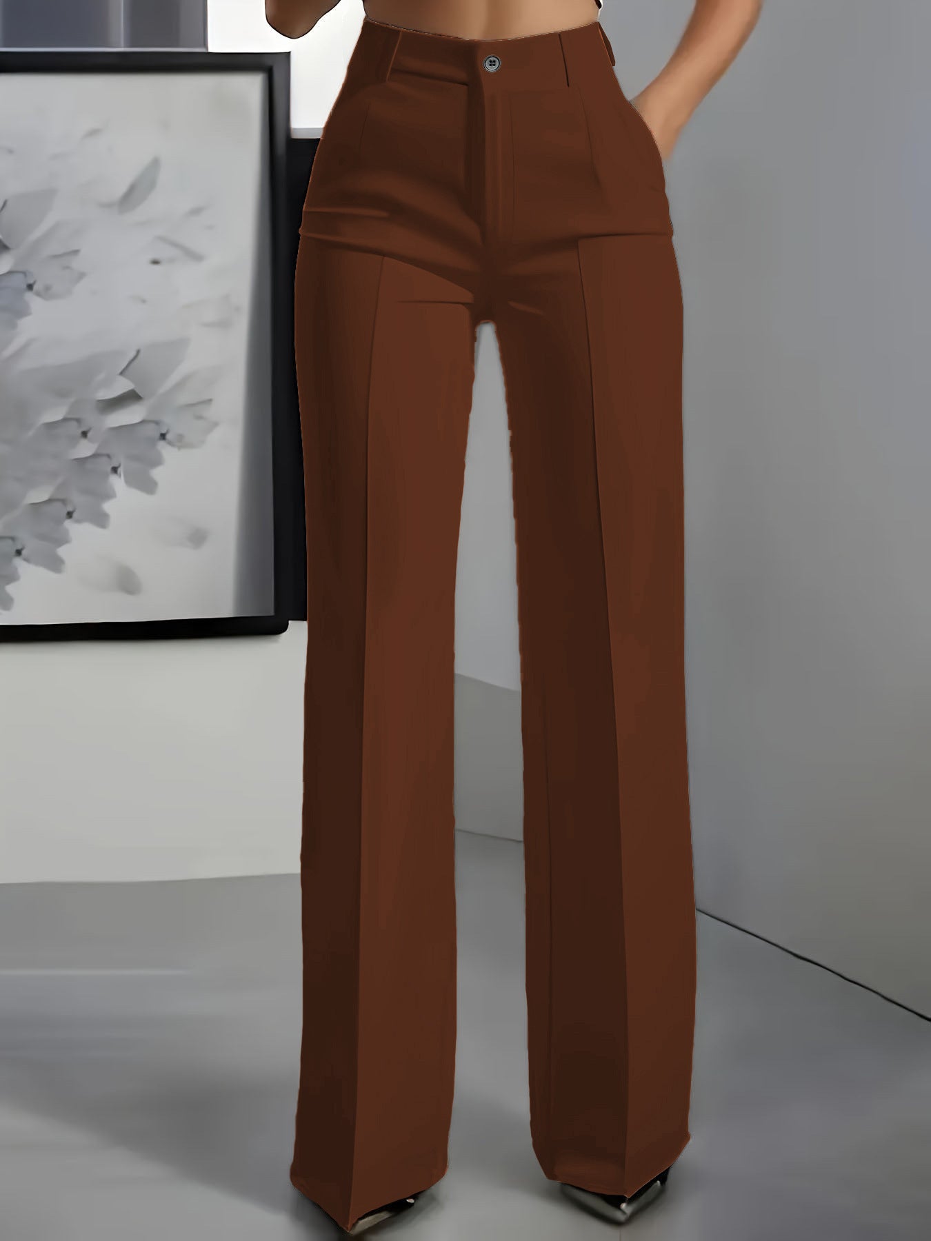 Brown high-waisted pants worn by a person against a plain background