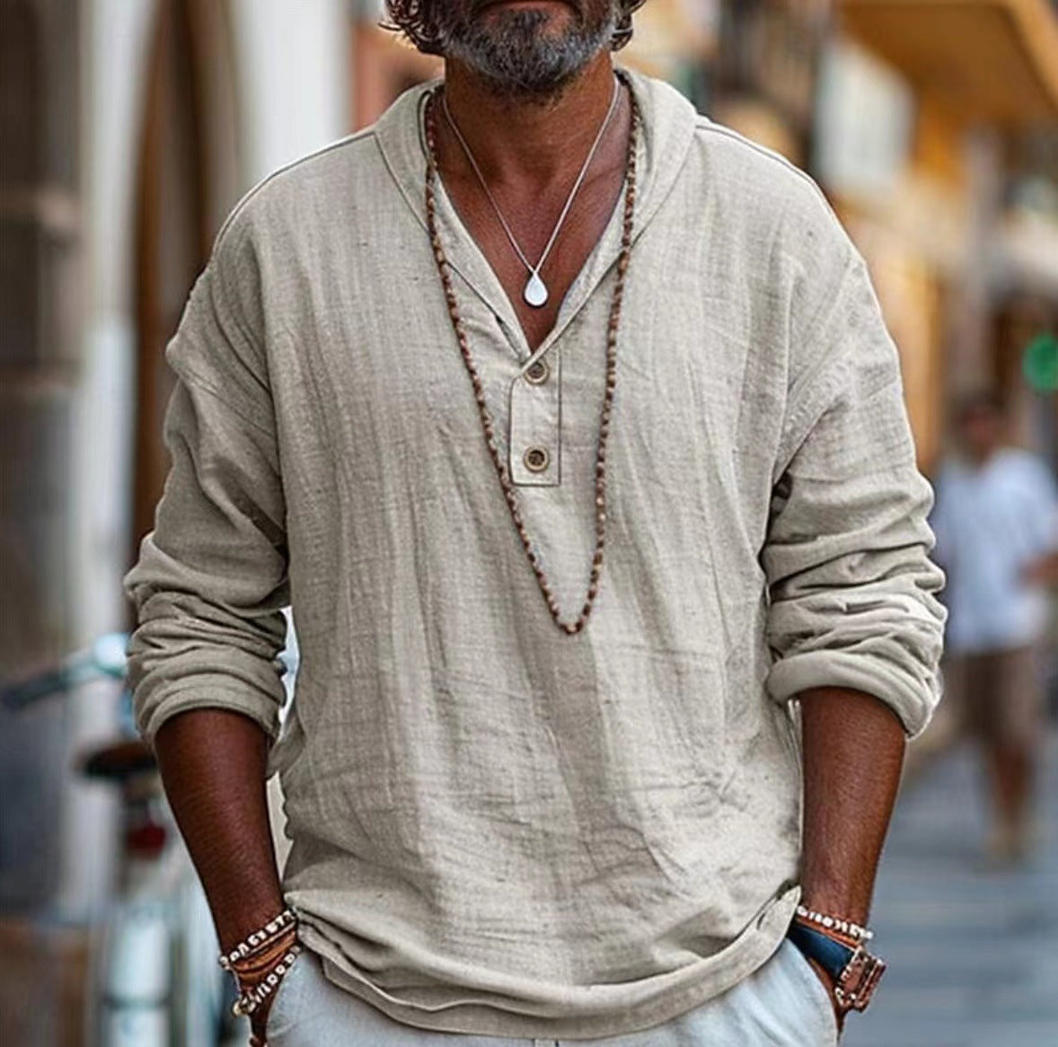 Man wearing a beige long-sleeve shirt with rolled-up sleeves in an urban setting