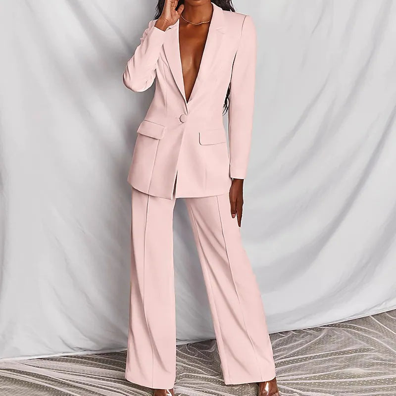 Person wearing a light pink suit against a plain background