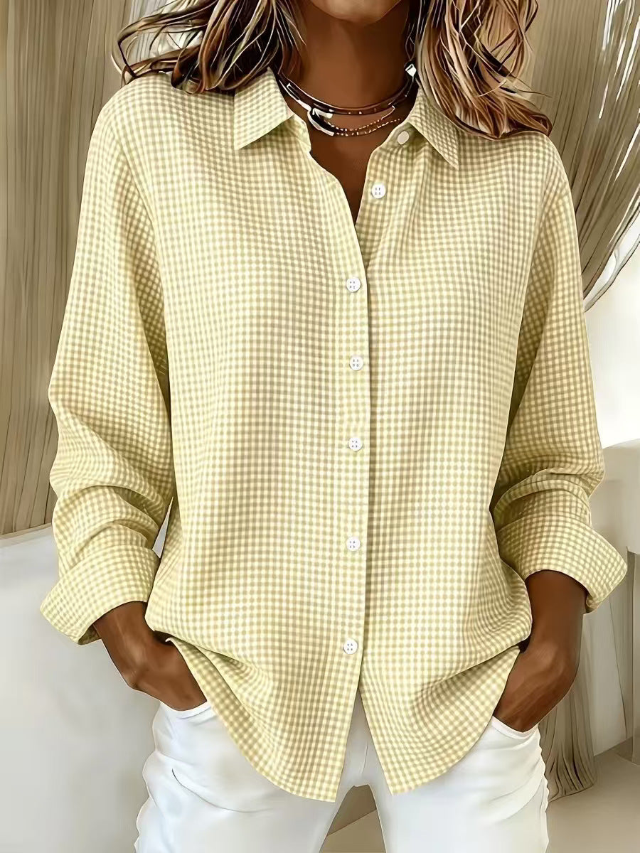 Person wearing a yellow checkered shirt with white pants indoors.