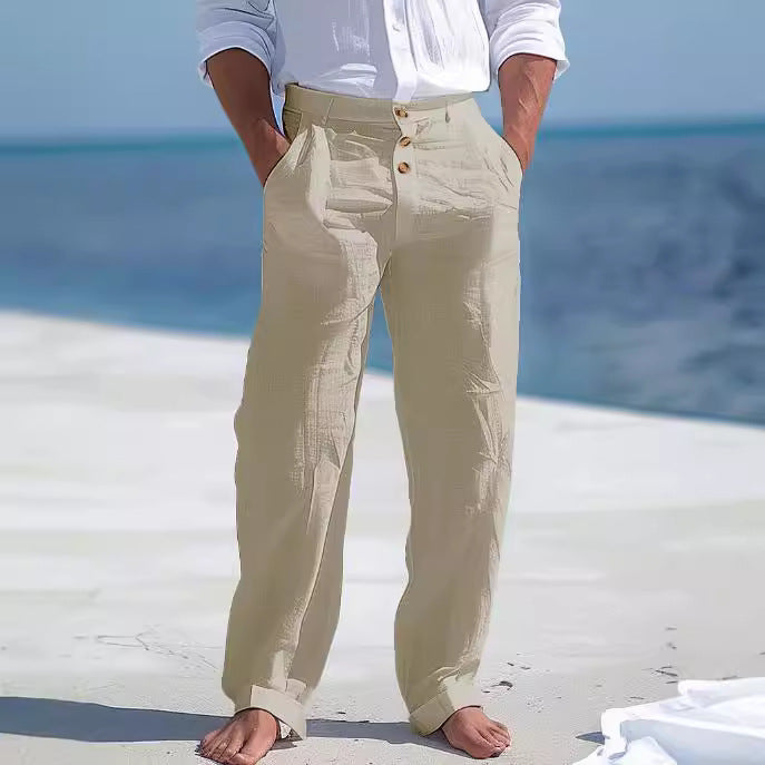 Person wearing beige pants with a blurred beach background