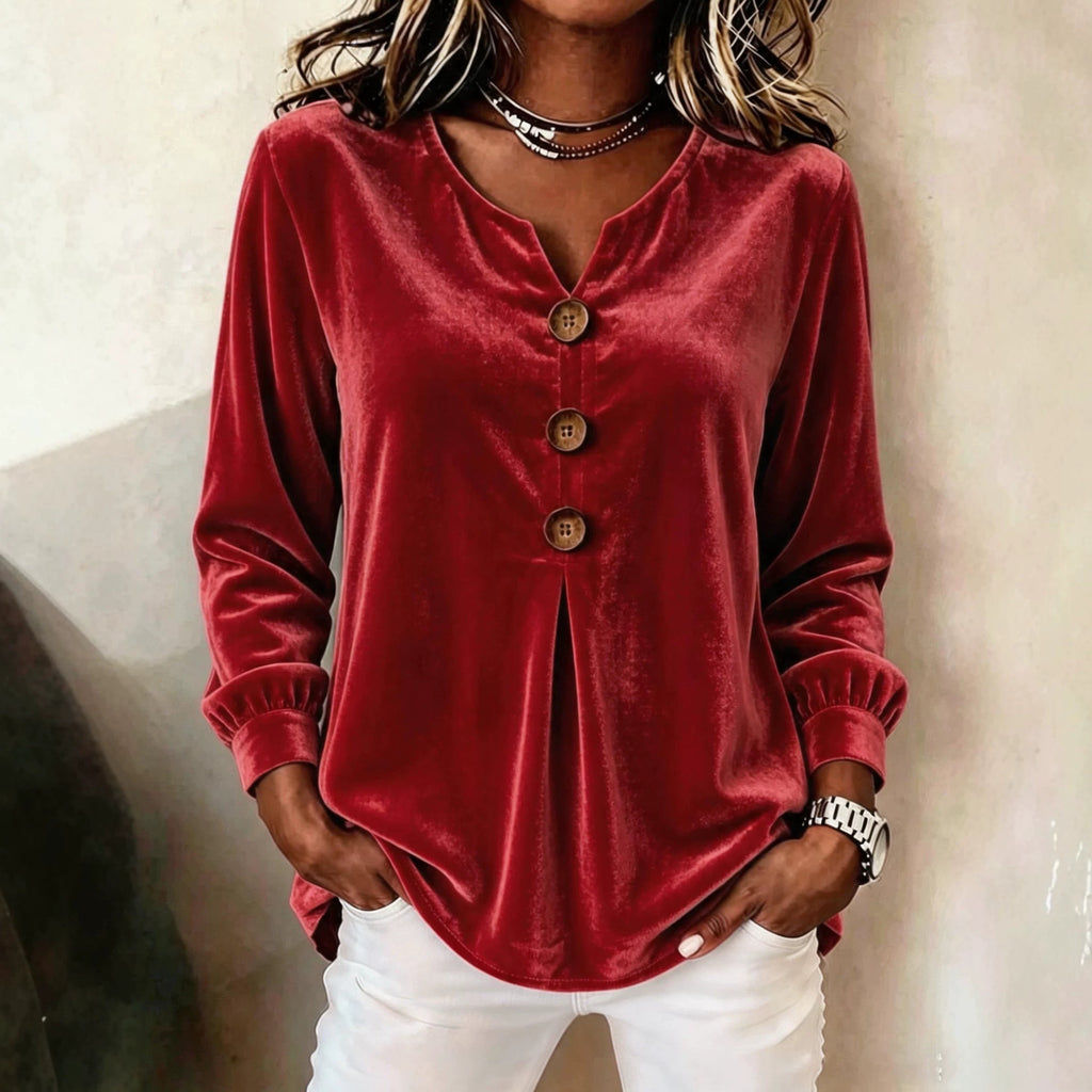 Red velvet long-sleeve top worn by a person against a neutral background