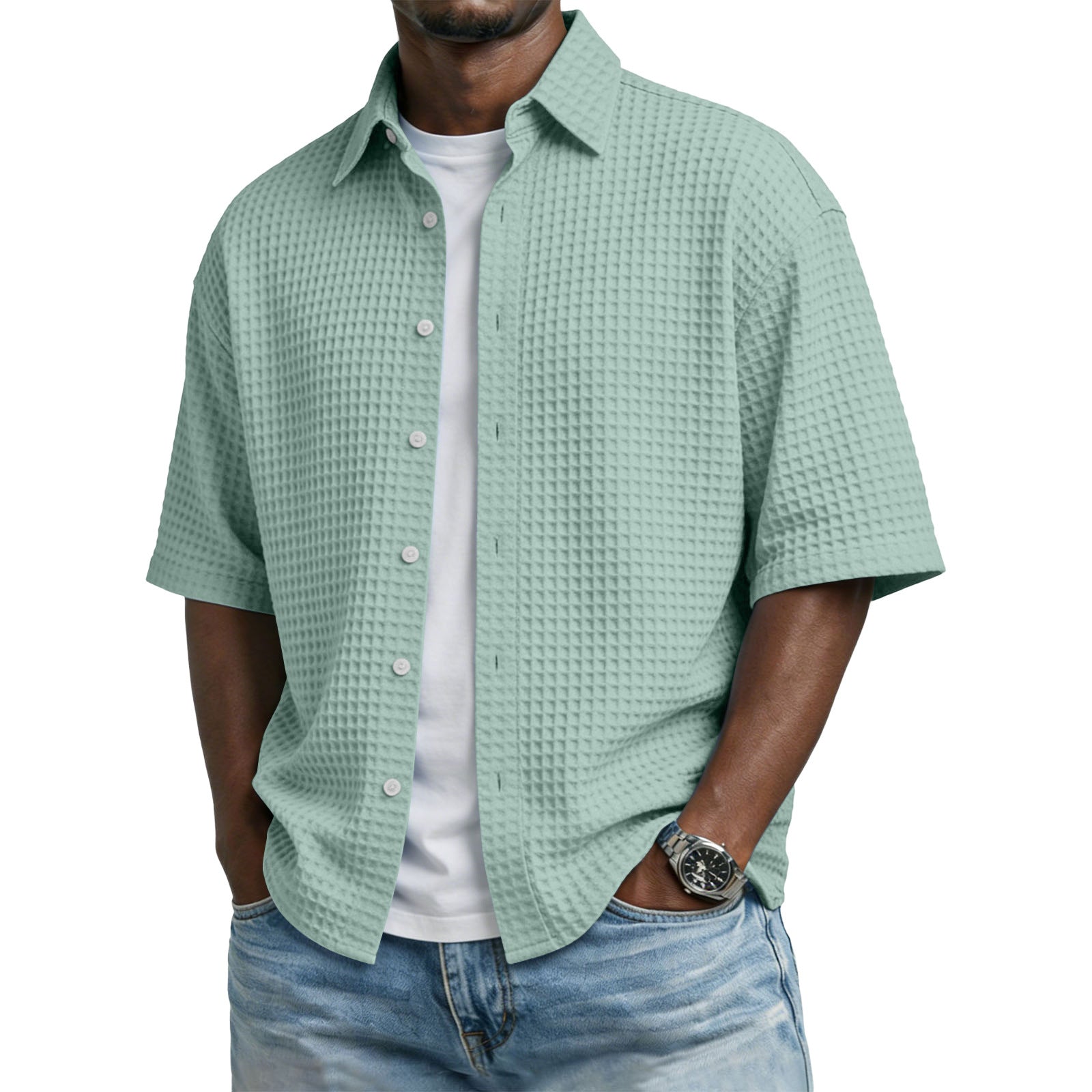 Man wearing a light green textured shirt over a white t-shirt with blue jeans on a white background