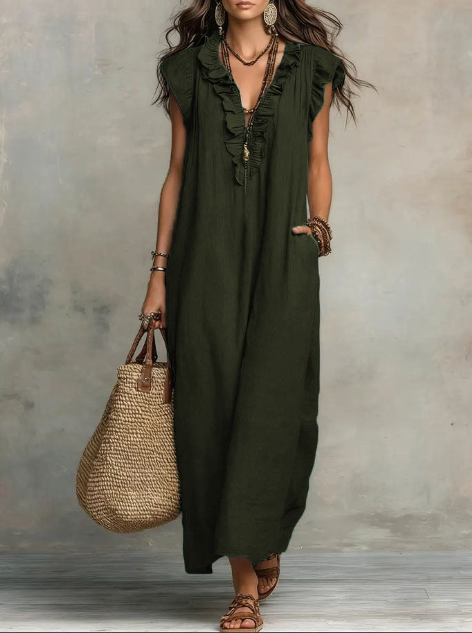 Woman wearing an olive green dress holding a woven bag against a neutral background