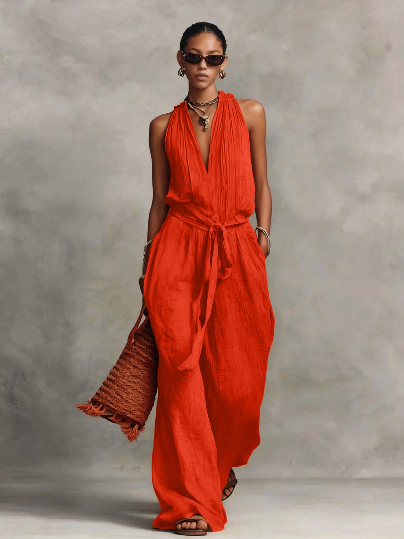 Woman wearing a red jumpsuit against a gray background