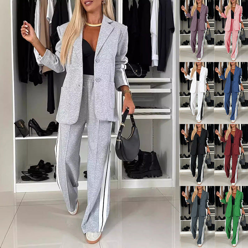 Woman in a gray suit standing in front of a wardrobe with multiple outfits displayed.