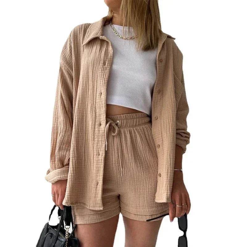 Woman wearing beige textured shirt and shorts set, white crop top, holding black purse