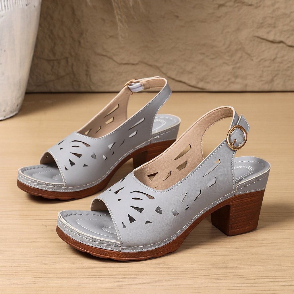 Pair of light blue sandals with wooden soles on a beige surface
