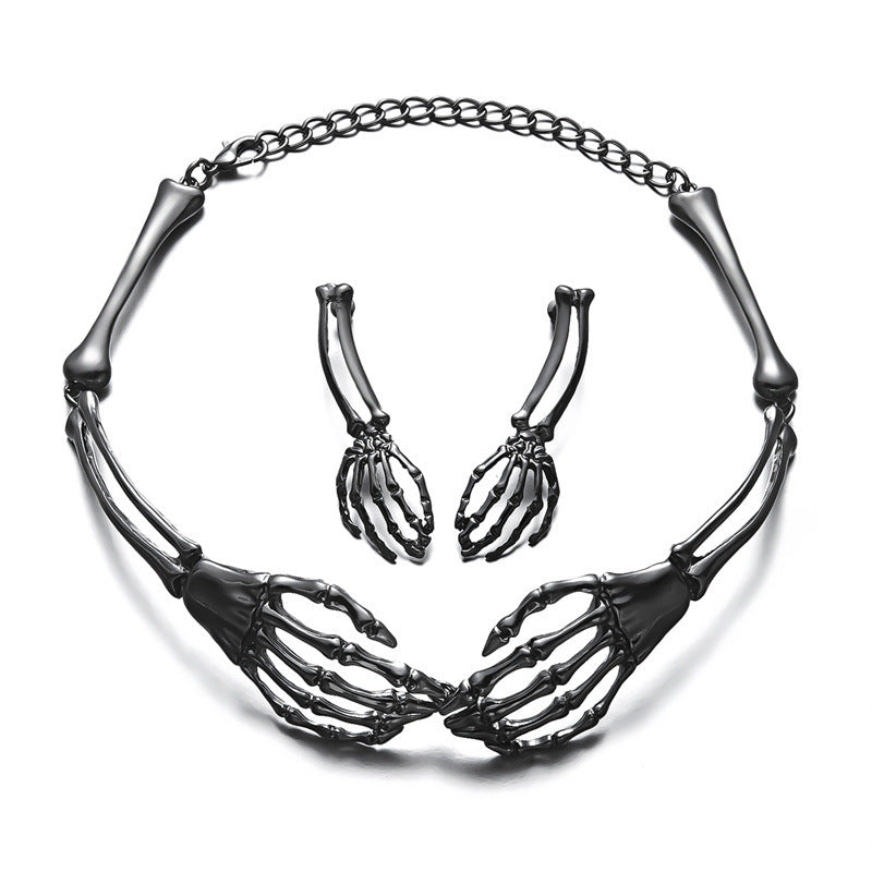 Black skeleton hand necklace and matching skeleton hand earrings on a white background.