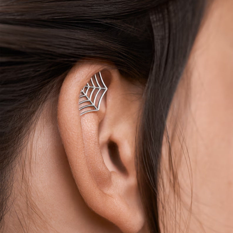 Silver leaf-shaped earring worn by a person with dark hair.