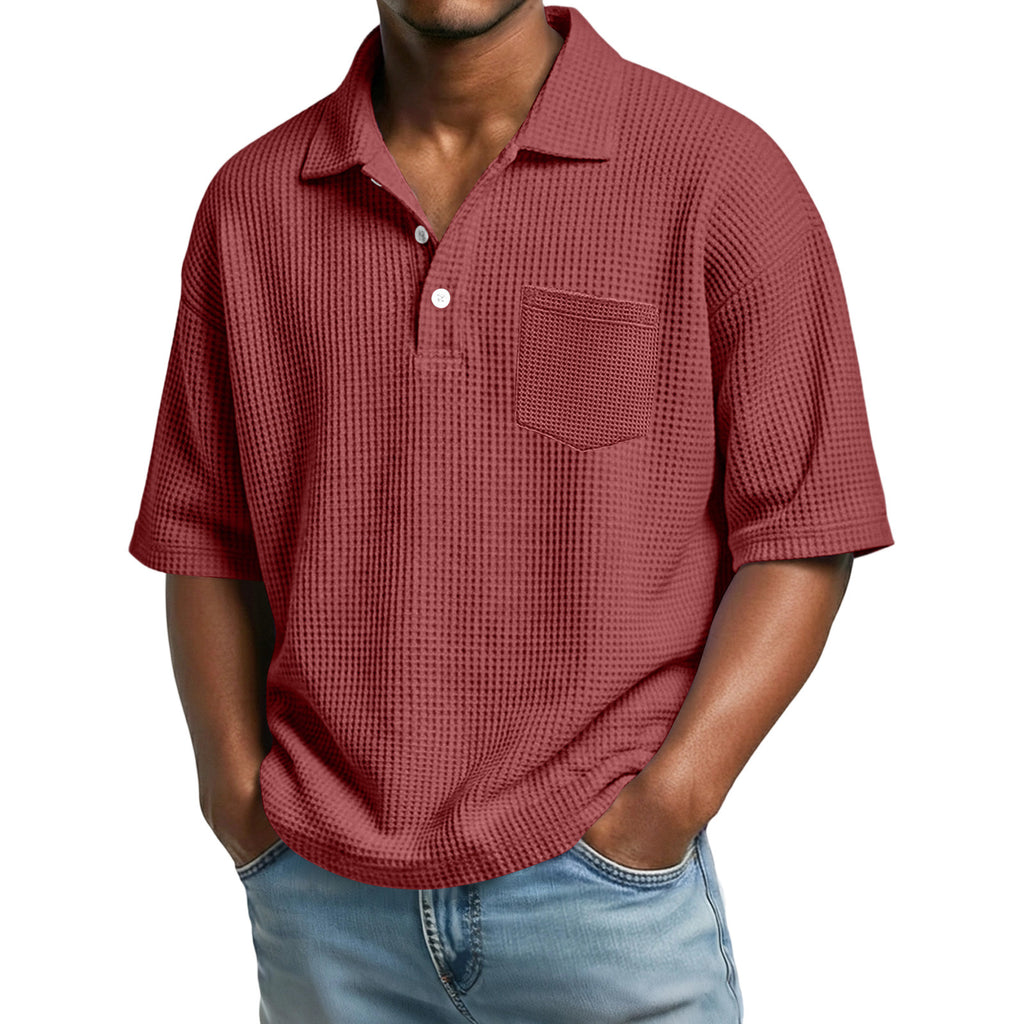 Man wearing a red textured polo shirt with a pocket on a white background