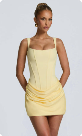 Woman wearing a yellow dress against a plain background