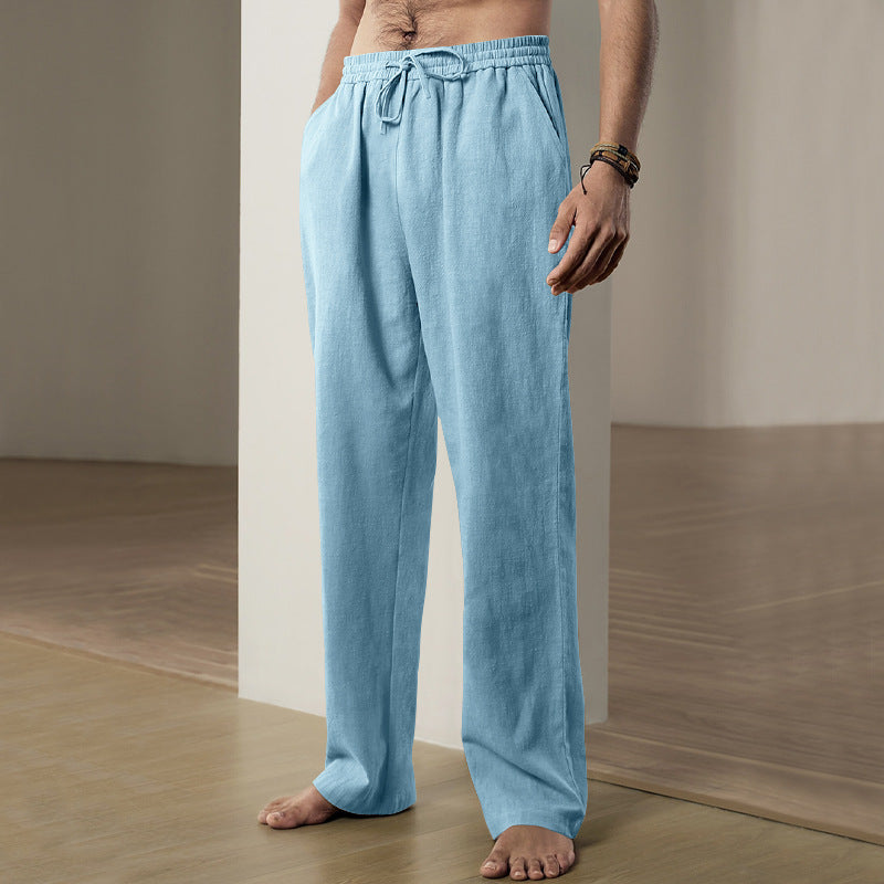 Person wearing light blue linen pants standing against a neutral background