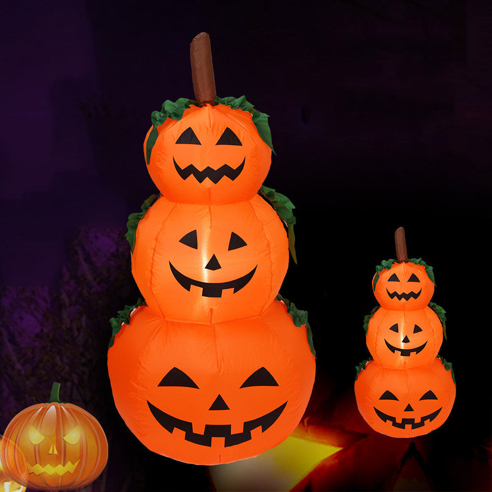 Stacked inflatable pumpkins with glowing faces on a dark background
