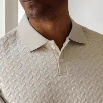 Close-up of a person wearing a textured beige sweater with a collar.