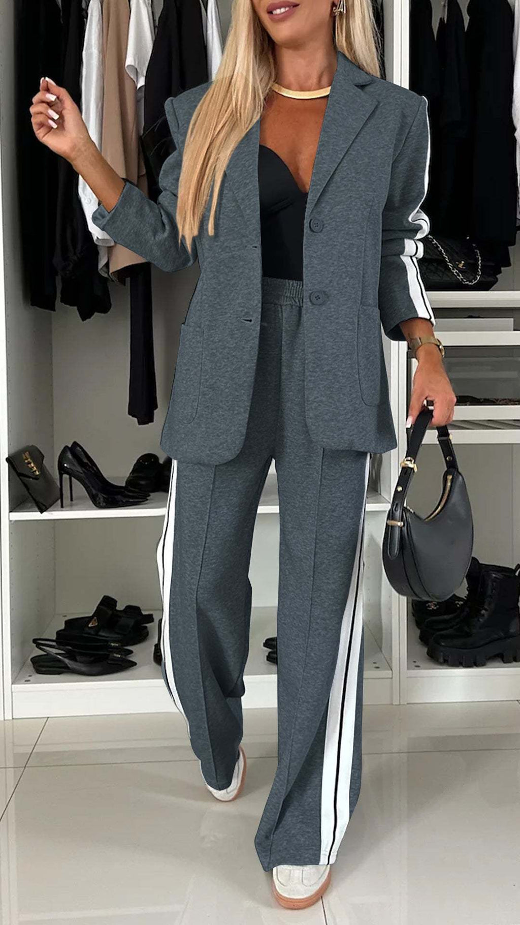 Woman in a gray suit with white stripes standing in a closet.