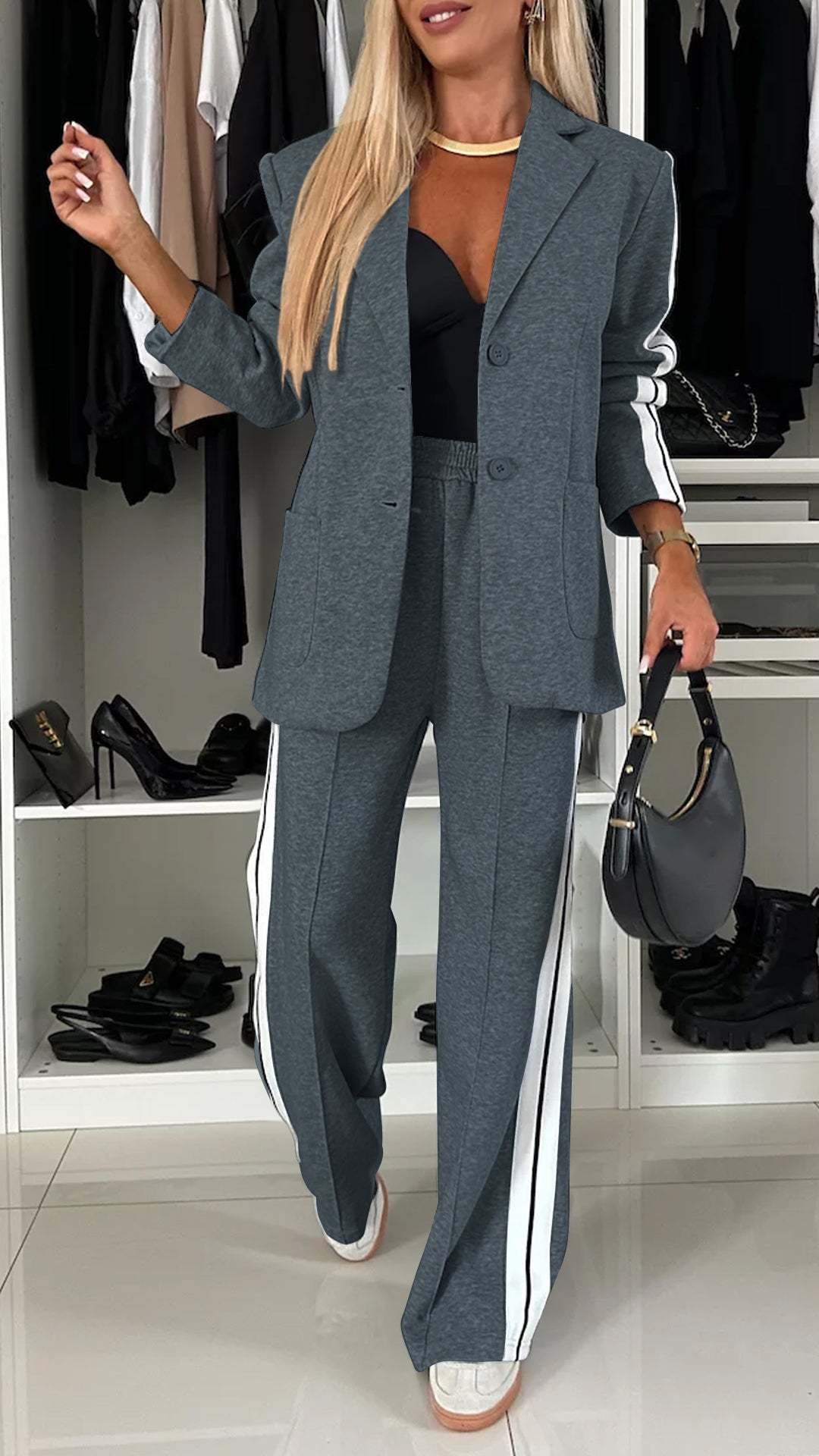 Woman in a gray suit with white stripes standing in a closet.